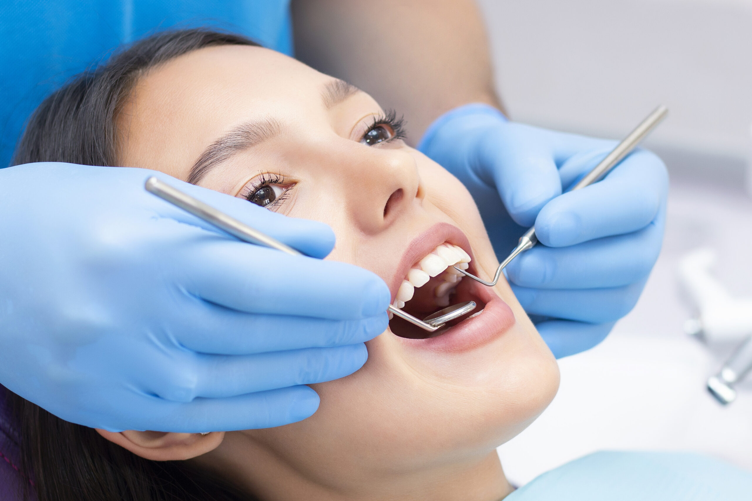 Young Female patient with pretty smile examining dental inspection at dentist clinic. Healthy teeth and medicine, stomatology concept